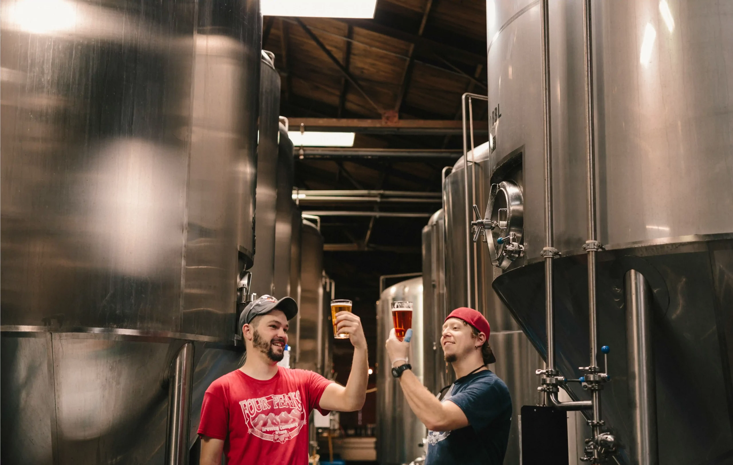 Deux hommes regarder l'aspect de leur bière au milieu de cuves