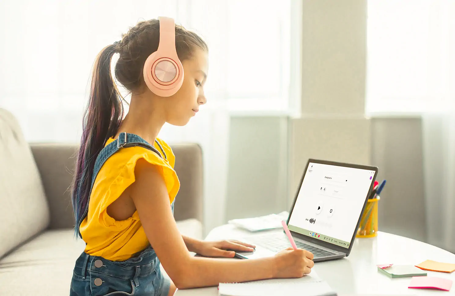Une fille prend des notes en écoutant son enregistrement sur Voice Recorder