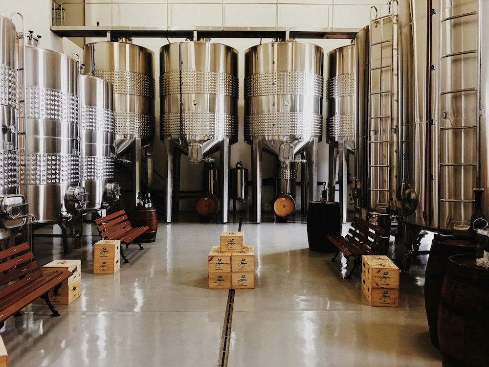 Cuves dans une brasseries avec des cartons de bières